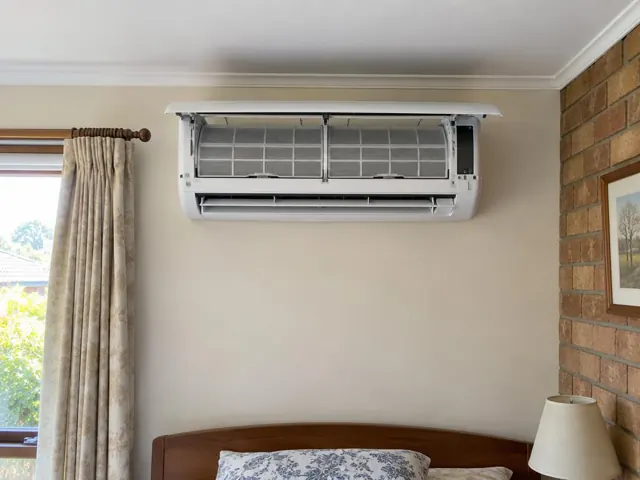 Open split system with clean filters on a beige wall above a bed in Salisbury Park